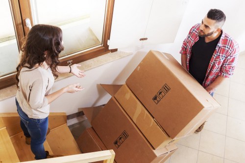 Movers handling boxes and furniture in a Belgravia apartment building